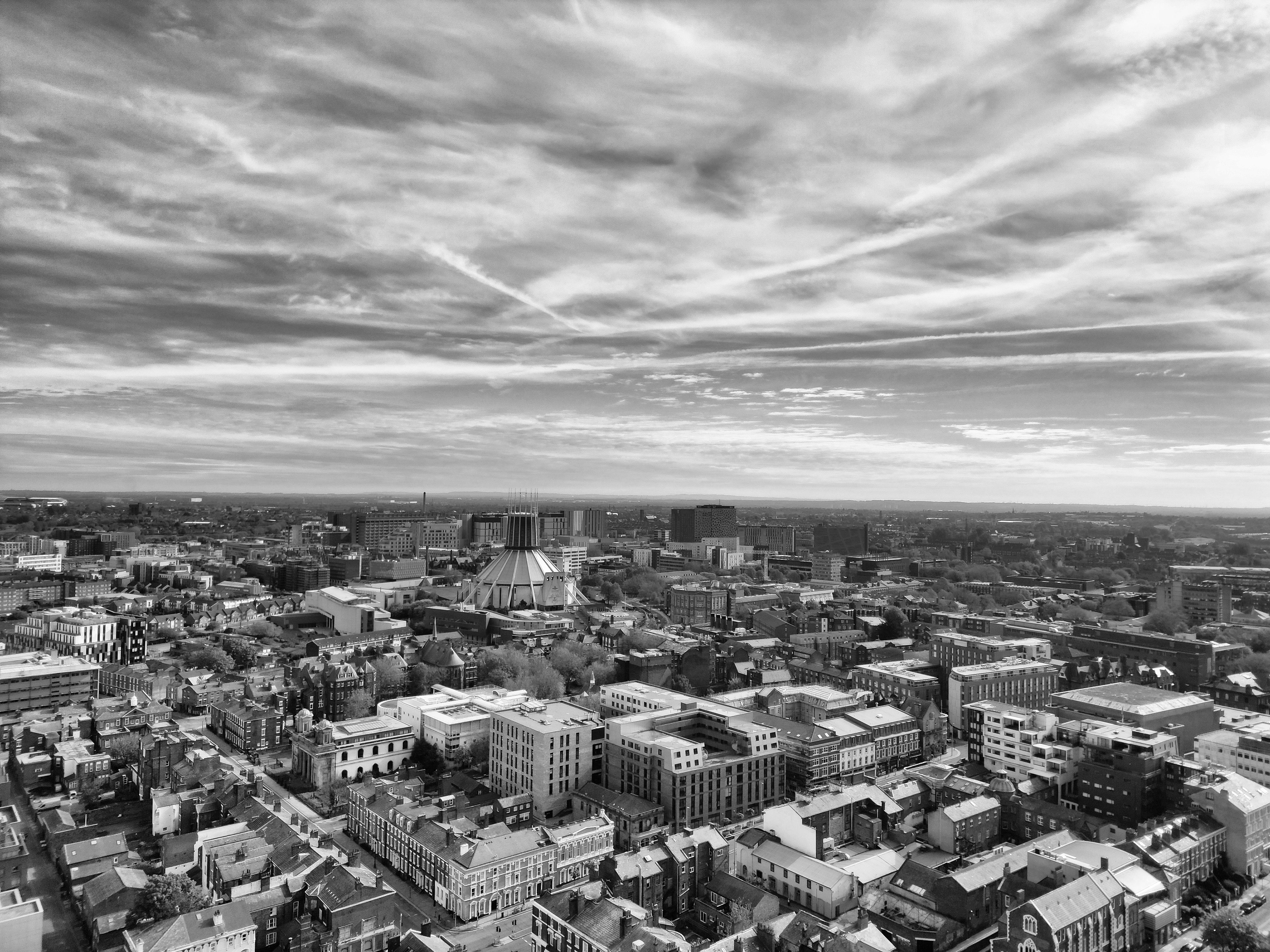 Black and white photo of a city with clouds · Free Stock Photo