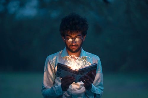 Foto gratuita de un hombre sosteniendo un libro