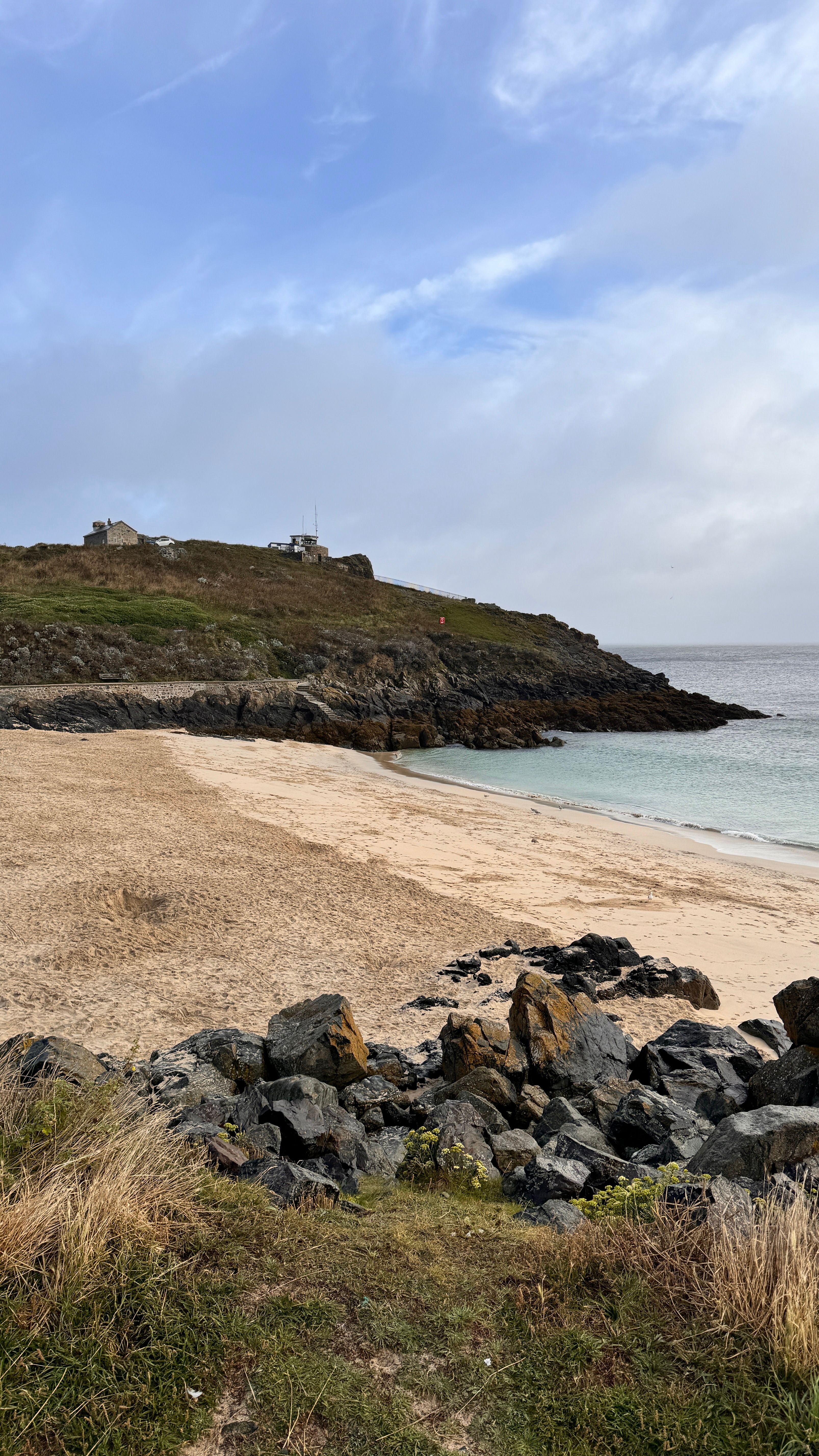 A beach with rocks and sand on it · Free Stock Photo