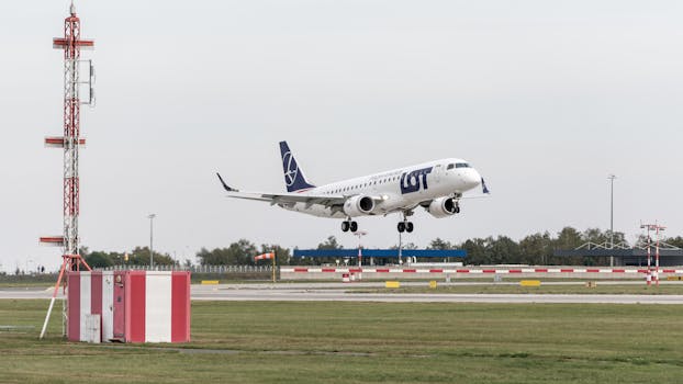 A LOT Polish Airlines plane landing at Prague Airport, showcasing aviation technology and travel.