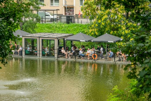 Relaxing outdoor cafe by the river in Wrocław, ideal for leisure and tourism.