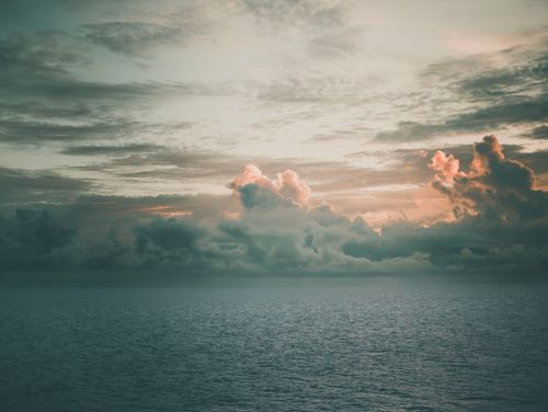 Free Serene sunset with dramatic clouds over the ocean in Manila Bay, creating a picturesque seascape. Stock Photo