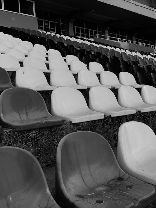 Free Monochrome image of empty stadium seats, providing a dramatic and timeless feel. Stock Photo