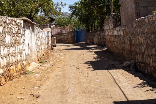 Explore the rustic stone-lined alleyways of Kuyu, Diyarbakır, a tranquil outdoor scene.