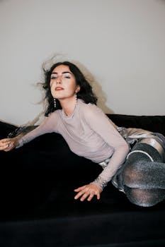 Stylish brunette woman in a fashionable outfit posing dramatically indoors.