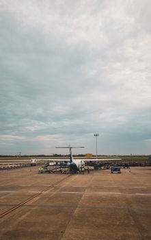 Airplane preparing for departure on a runway under a cloudy sky in Chennai, India.