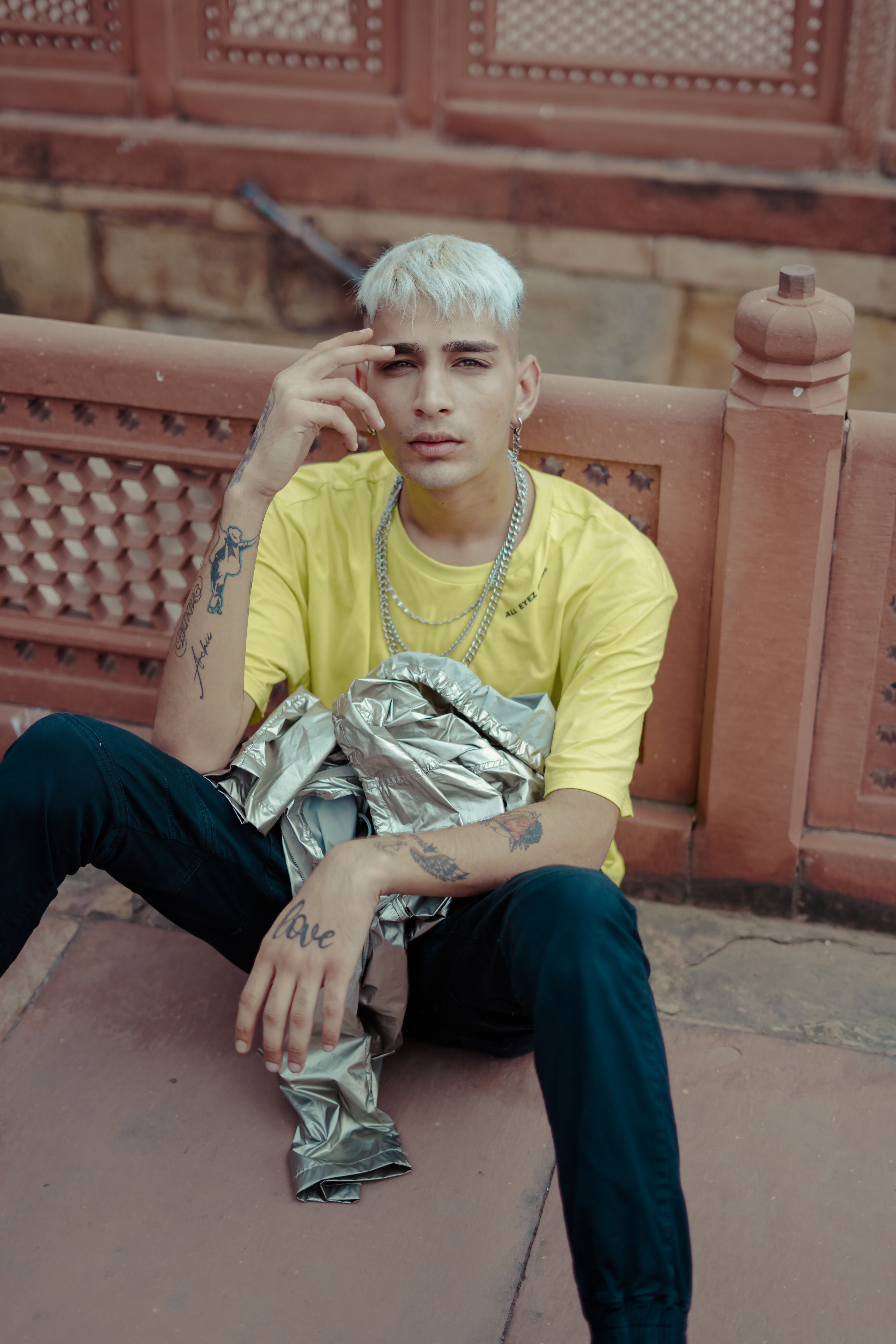 Portrait of a stylish young man with tattoos, posing outdoors in New Delhi.