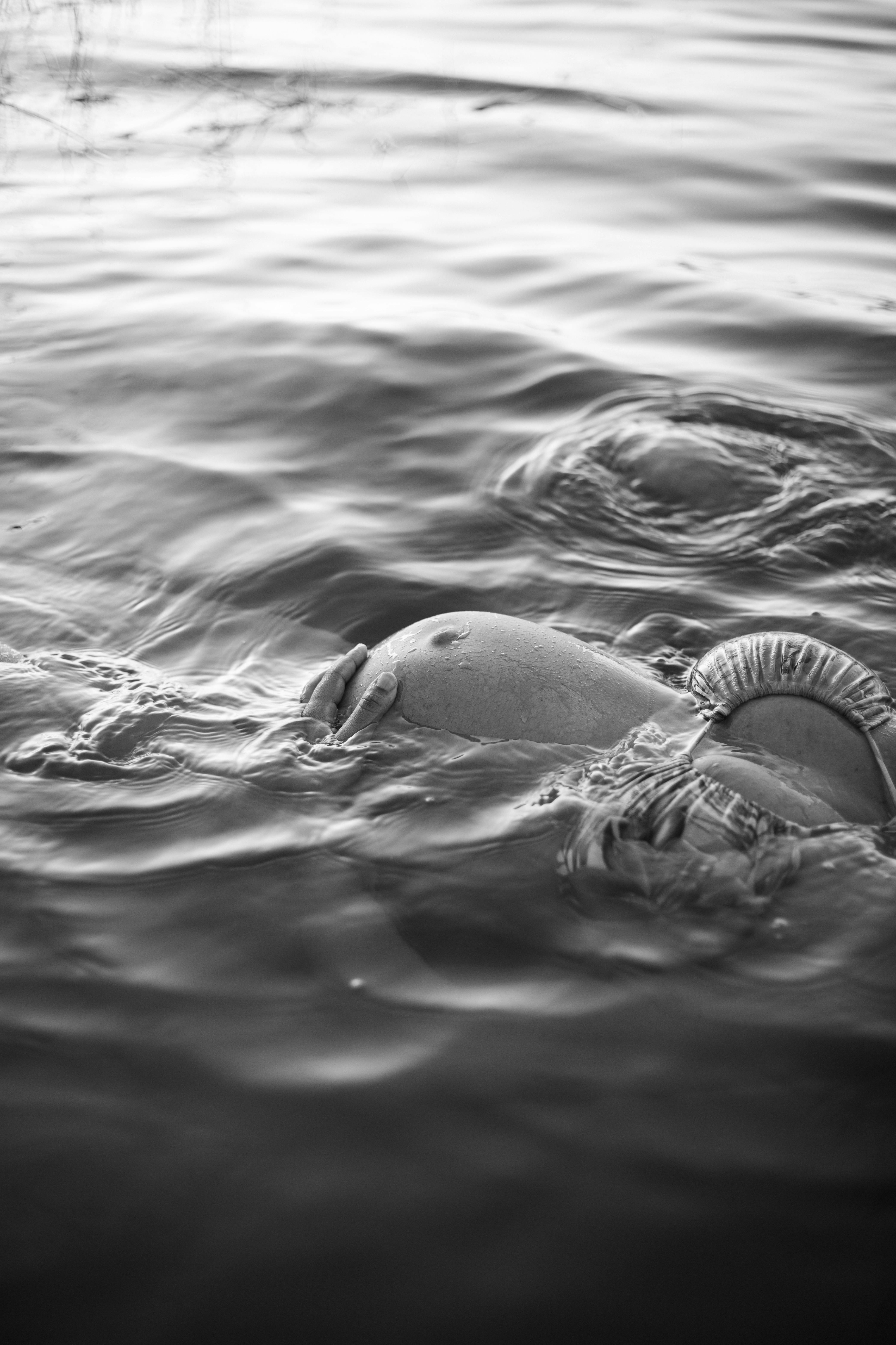 a black and white photo of a man swimming in the water