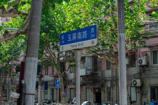 Street sign on Yuping Road in a leafy urban neighborhood, capturing vibrant city life.