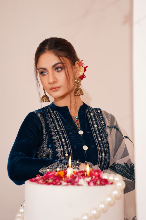 Free Beautiful woman in blue traditional attire posing with a decorated cake indoors. Stock Photo
