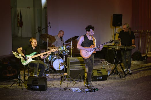 A band performing live music on stage with guitar, bass, and drums.