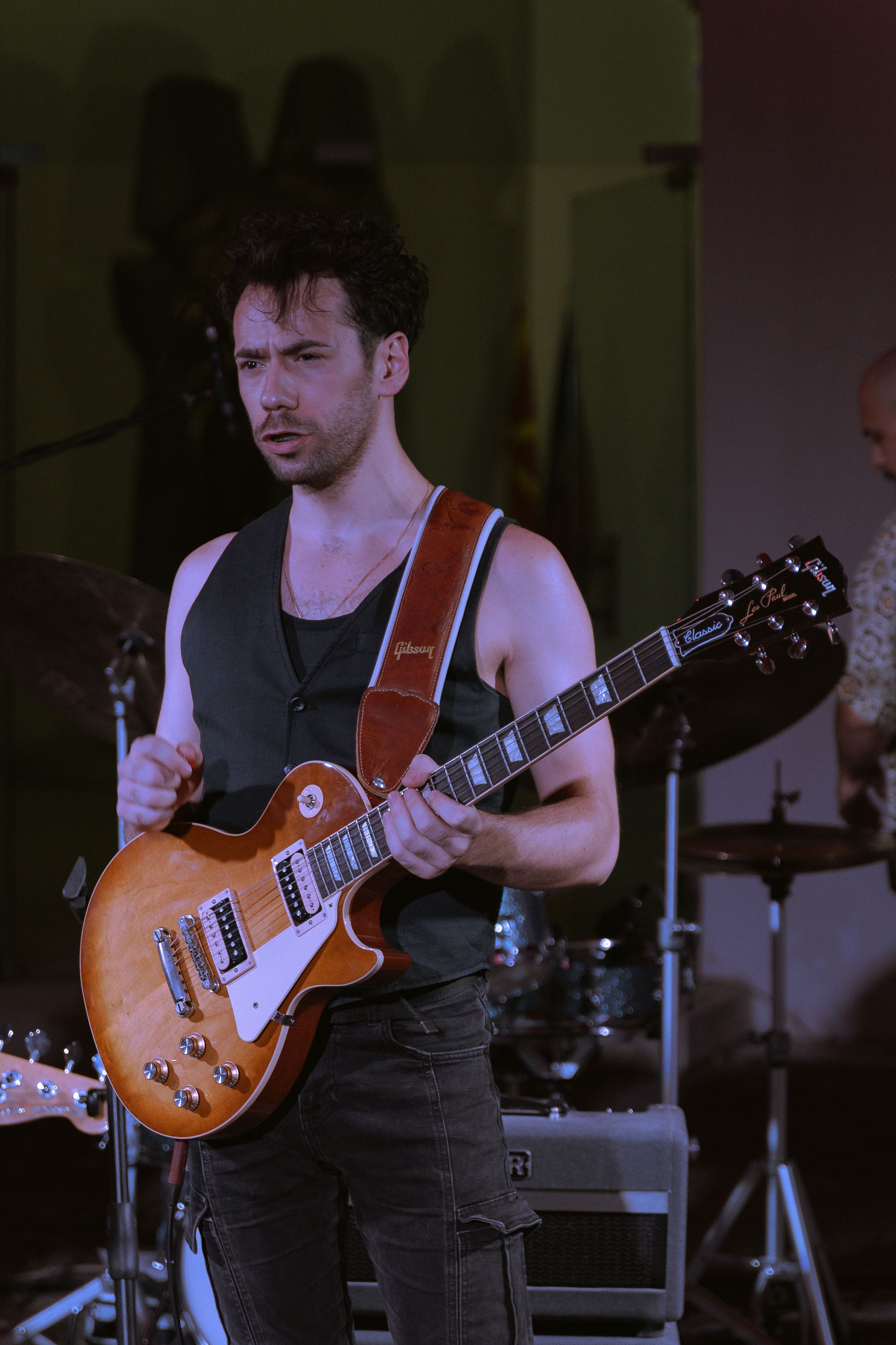 A male guitarist passionately performs on stage during a lively concert.