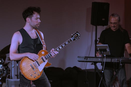 A guitarist and keyboardist perform live on stage, showcasing their musical talents.