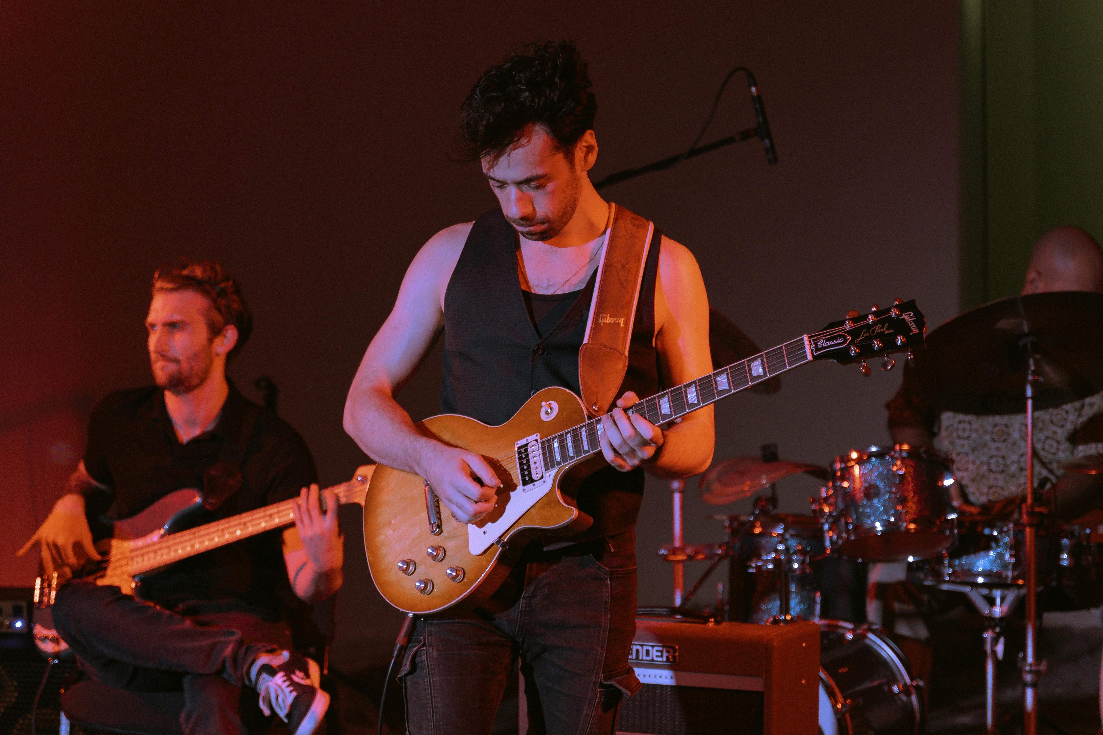 a man playing guitar with other musicians