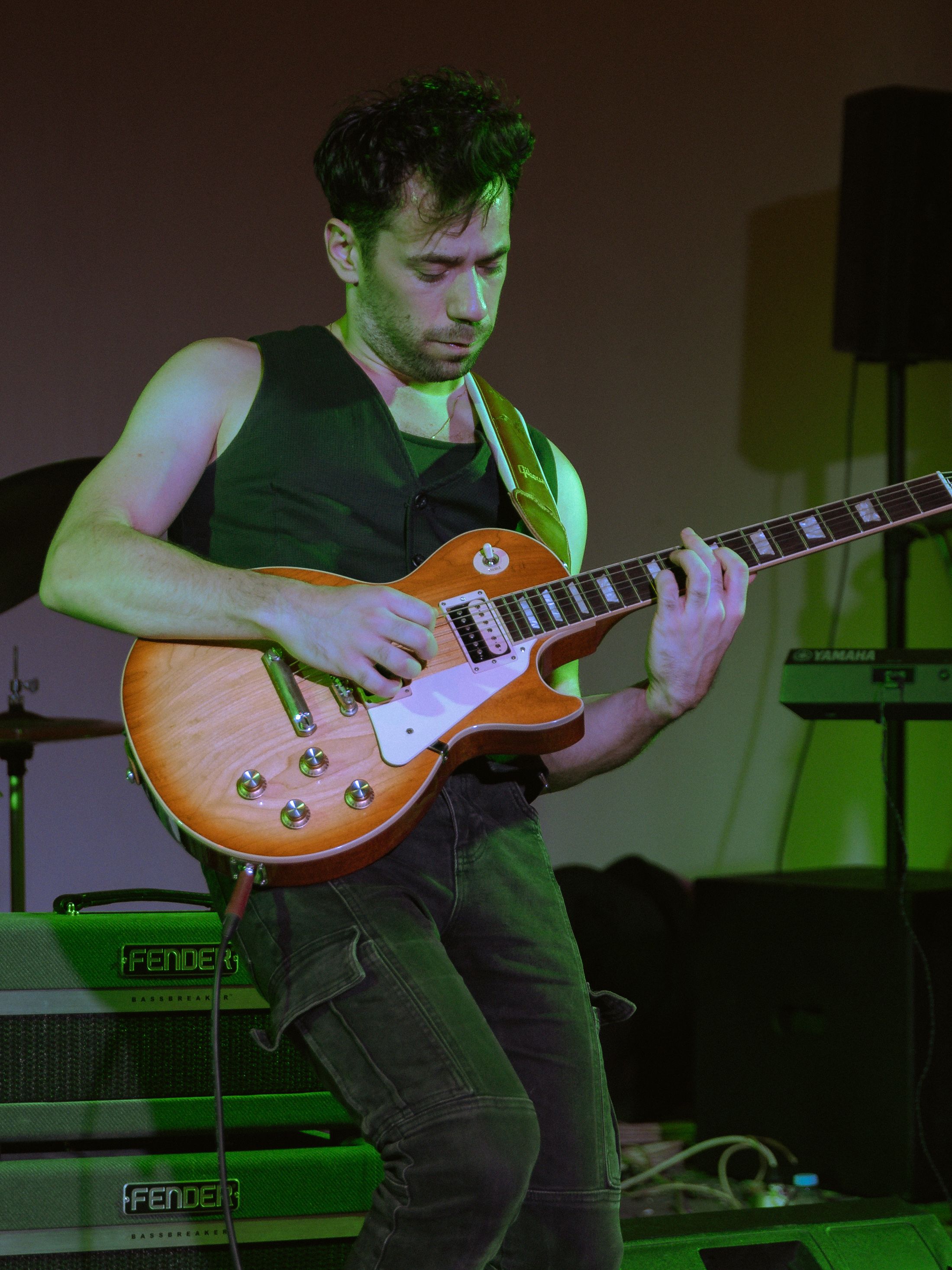 Dynamic guitarist playing electric guitar on stage during a live rock performance.