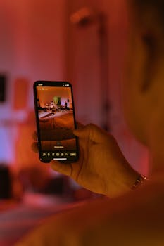 A person uses a smartphone to view a colorful indoor scene with vivid lighting.
