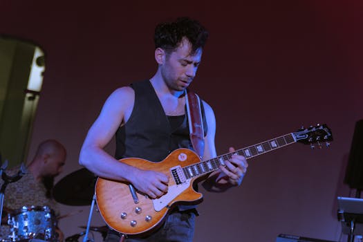 Musician passionately playing electric guitar on stage during a live concert.