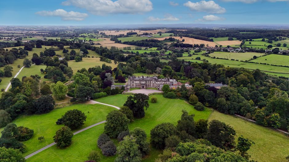Aerial view of an English country estate with house, gardens and surrounding fields, illustrating the SDLT mixed-use grounds question