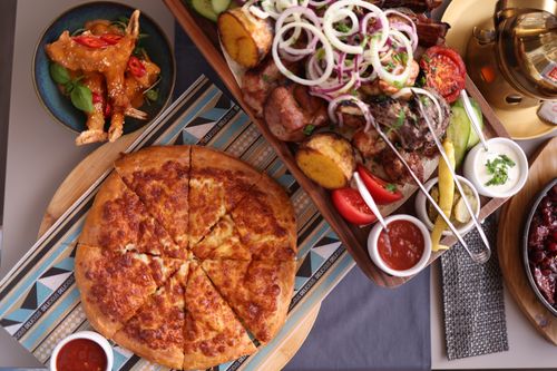 Free A vibrant top-down view of a delicious spread including pizza and assorted meats. Stock Photo