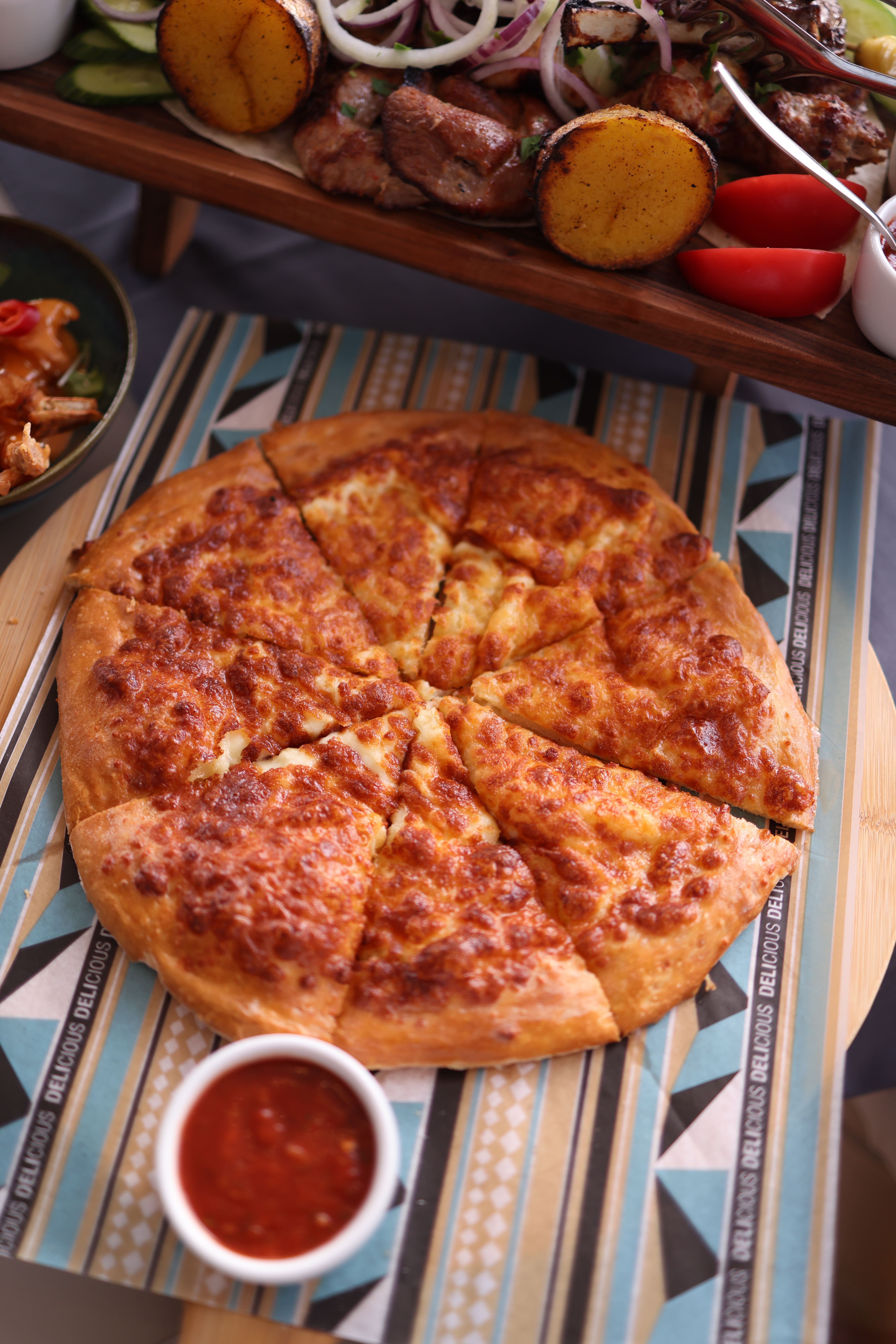 Delicious baked cheese pizza with dip, perfect for sharing at meals.