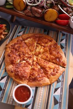Delicious baked cheese pizza with dip, perfect for sharing at meals.