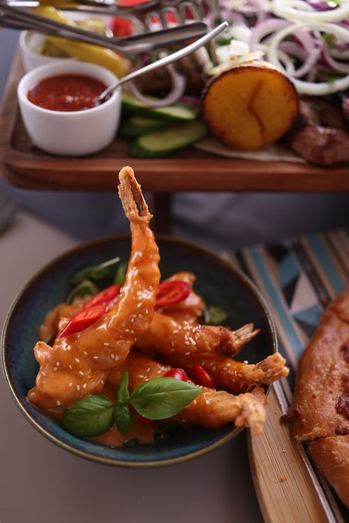 Free Delicious shrimp in chili sauce garnished with fresh basil, perfect for a vibrant meal. Stock Photo