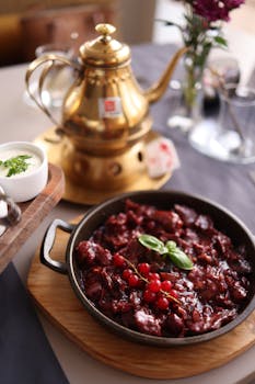 A traditional homemade dish with berries and a golden teapot set in a rustic theme.