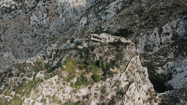 Explore the ancient Kotor Fortress with this breathtaking aerial view of Montenegro's rugged landscape.