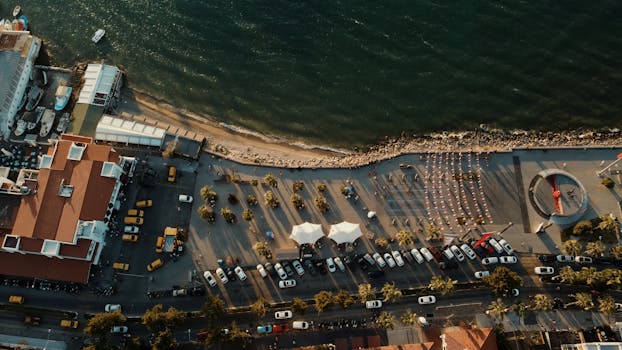 Captivating aerial shot of Kuşadası waterfront in Türkiye during golden hour, showcasing urban and coastal harmony.