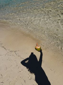 Explore the tropical beach with a coconut drink and shadow play captured in Ciego de Avila, Cuba.