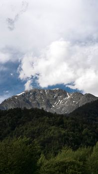 Breathtaking mountain landscape with snow-capped peaks and lush forest in Şeki, Azerbaijan.