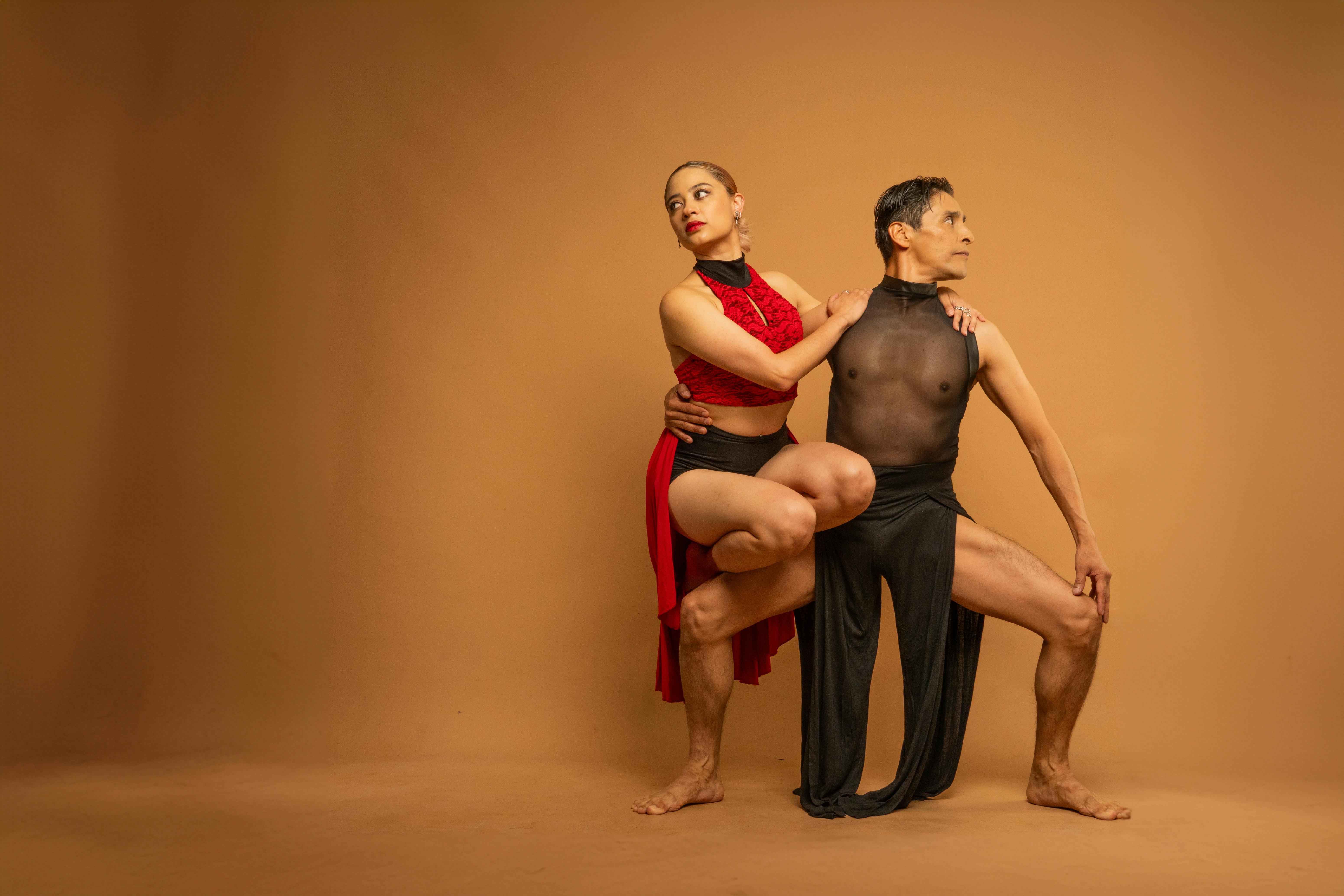 two dancers in a pose on a brown background