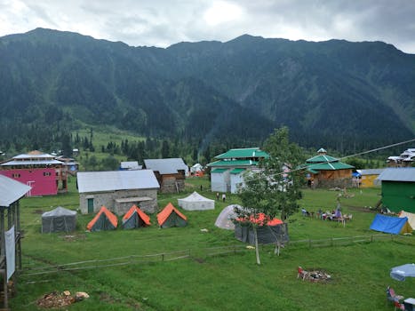 Explore the picturesque tents and cabins in Arang Kel against a stunning mountainous backdrop.