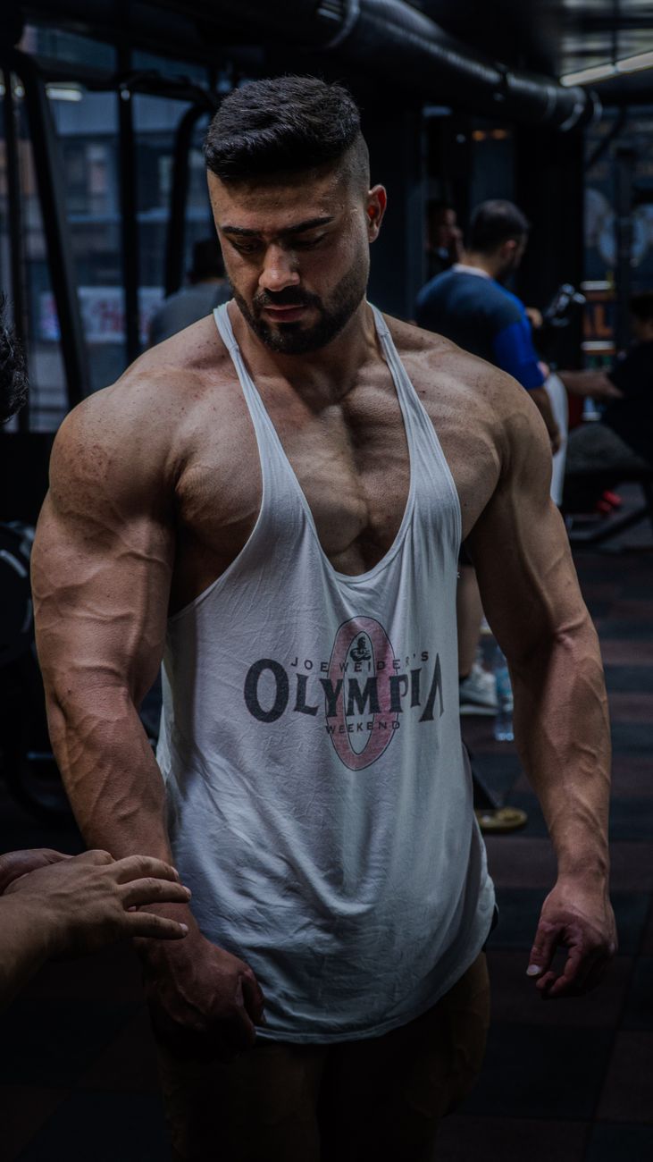 Strong muscular man in a gym focusing on bodybuilding and strength training.