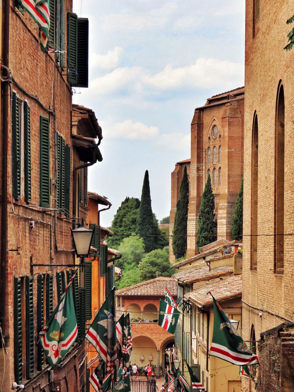 Stradă îngustă din Siena decorată cu steagurile contradelor
