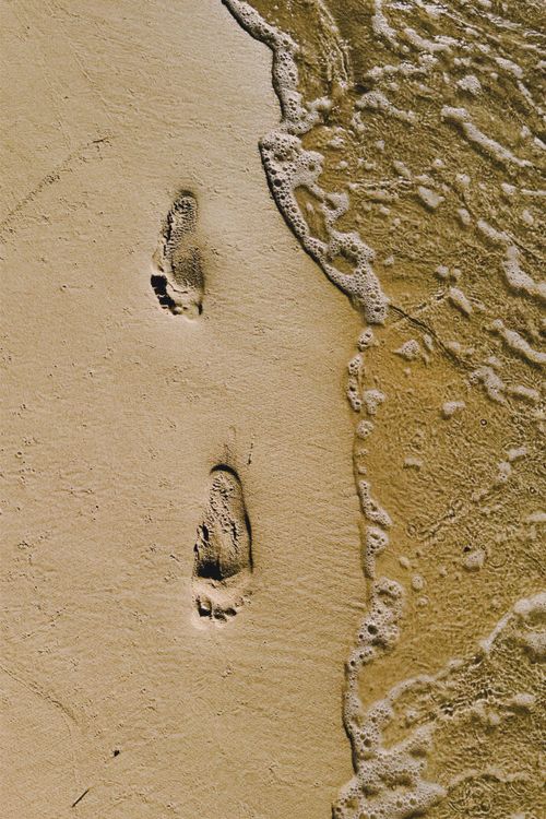 Free Footprints in the sand near ocean waves on a sandy beach in Ciego de Avila, Cuba. Stock Photo
