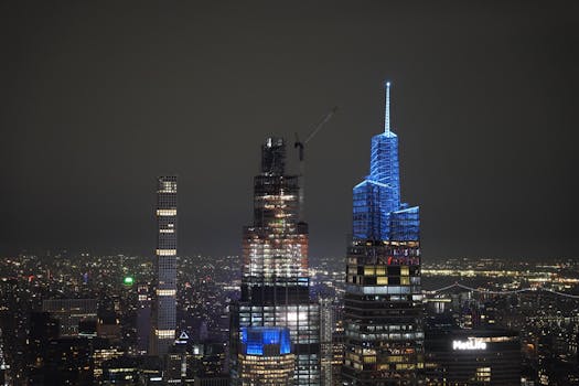Dramatic view of New York City's illuminated skyline at night featuring iconic skyscrapers and urban landscape.
