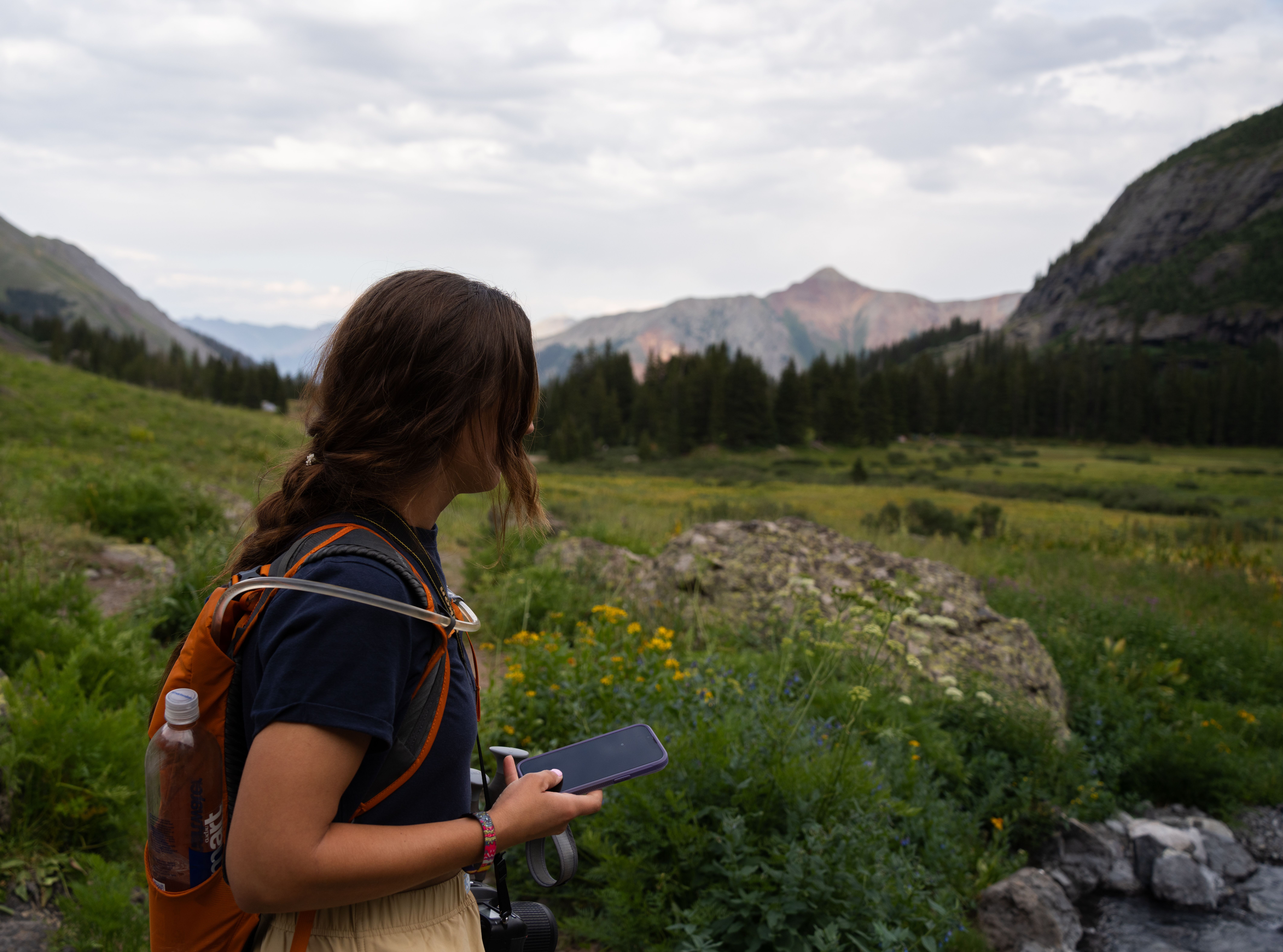 Excursionista comprobando la cobertura de la eSIM en una zona de montana rural