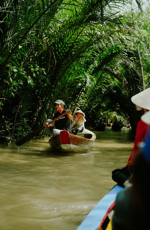 Free Experience a serene boat journey through Tien Giang's lush tropical waterways, Vietnam. Stock Photo