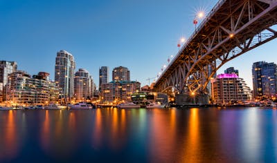 Downtown Vancouver is the city's bustling heart, encompassing vibrant neighborhoods like Yaletown, West End, and Coal Harbour. The image might showcase the sleek skyscrapers of Coal Harbour set against the backdrop of the shimmering Burrard Inlet and Stanley Park. Yaletown could be represented by its chic waterfront vibe, historic redbrick buildings, and trendy restaurants, while the West End offers a mix of modern condos and charming heritage homes nestled near lush parks and the famous English Bay beaches. Together, these areas create a dynamic urban core with a perfect balance of natural beauty, luxury living, and vibrant culture.