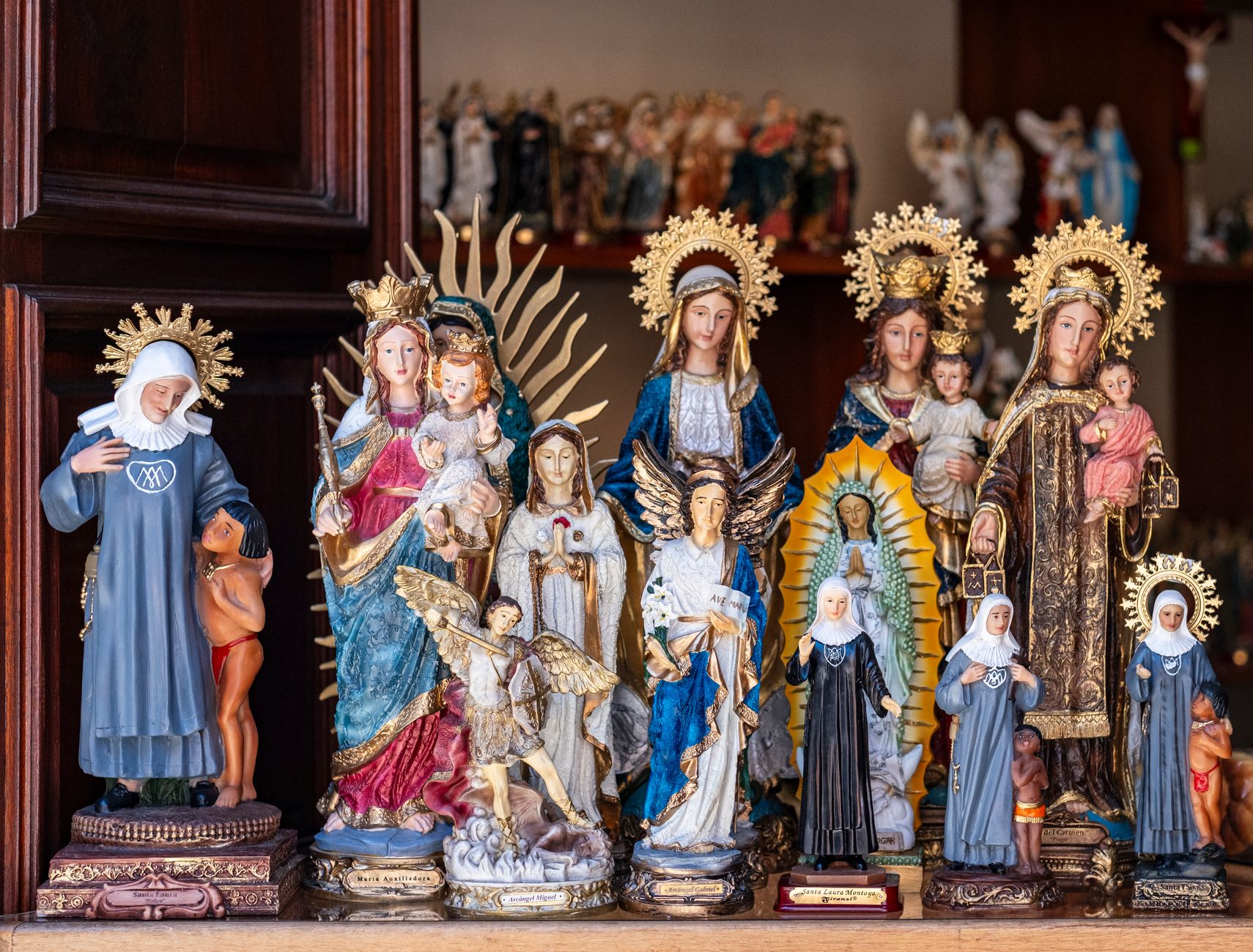 Vibrant display of religious statues in a shop in Jardín, Colombia, showcasing traditional Catholic icons and art.