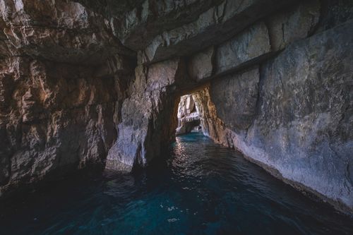 Free Explore the serene beauty of a limestone cave with water flowing gently through it, creating a breathtaking natural scene. Stock Photo