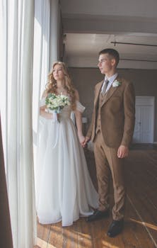 A couple holding hands, bride in white gown, indoors during a wedding.