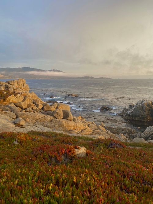 Free Breathtaking view of rocky coastline and ocean waves at sunset, showcasing nature's tranquility. Stock Photo