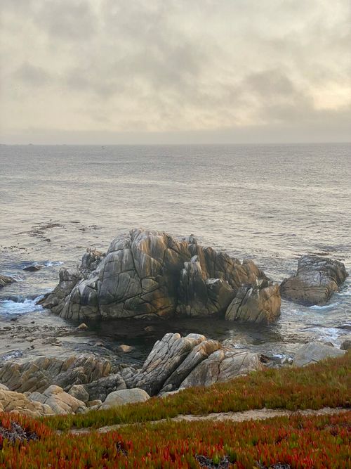 Free Beautiful rocky coastline at sunset with serene ocean waves. Stock Photo