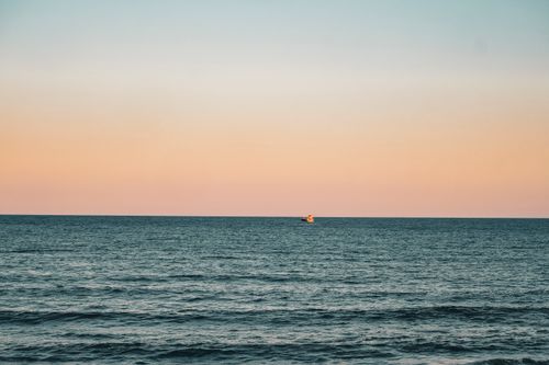 Free A tranquil sunset scene over the sea in Igneada, Türkiye with a distant ship. Stock Photo