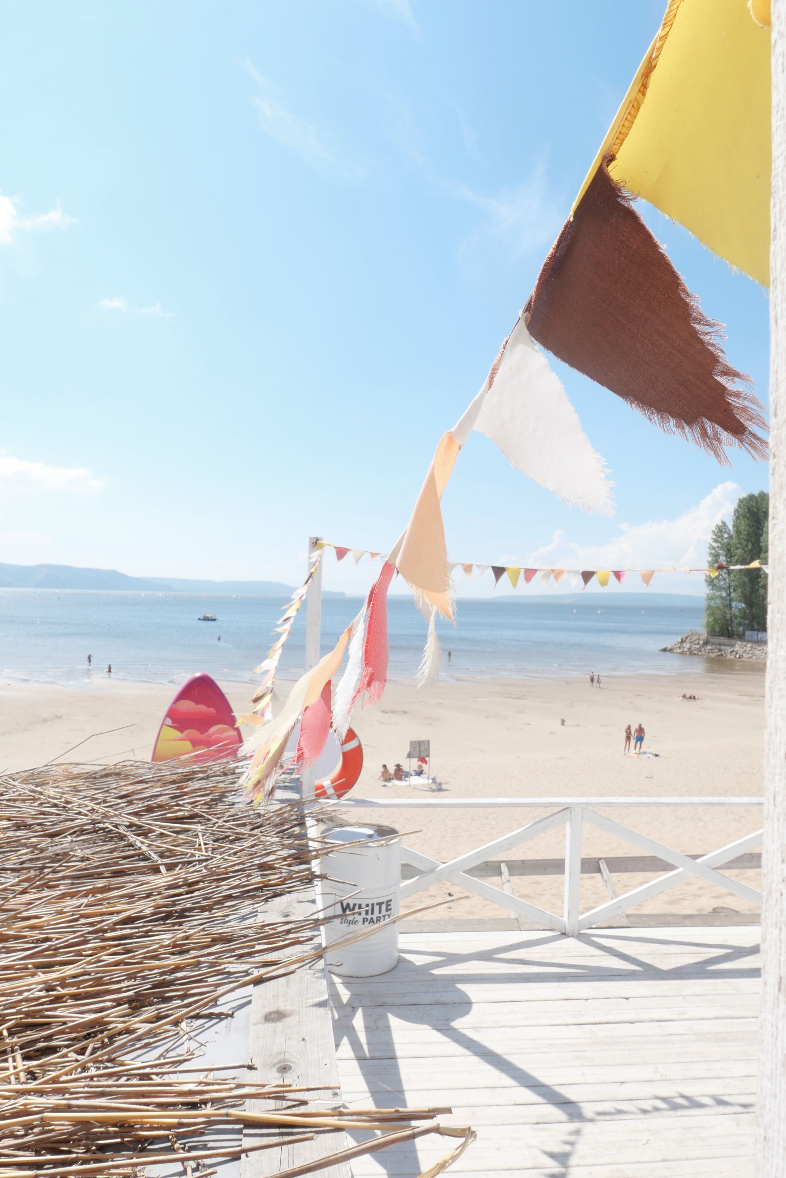 A beach with flags and a wooden fence · Free Stock Photo