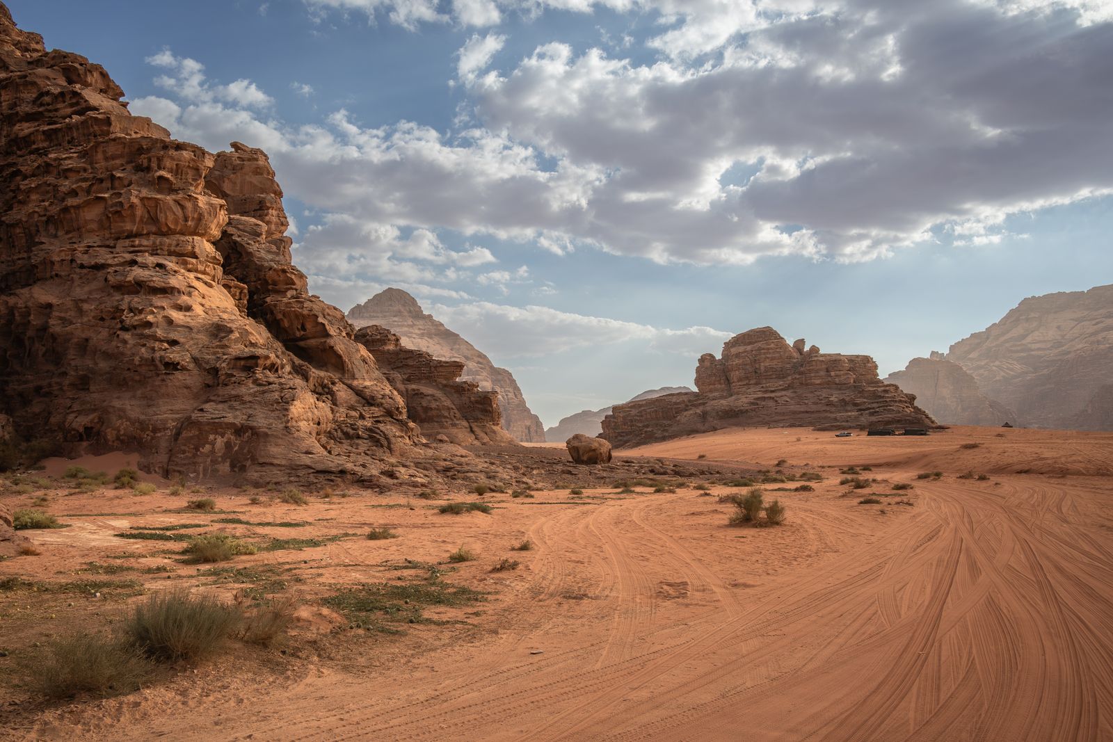 Sandstone cliffs rising above a desert track in Wadi Rum