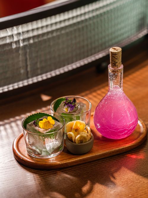 Free Vibrant pink potion and tropical snacks beautifully arranged on a wooden platter. Stock Photo