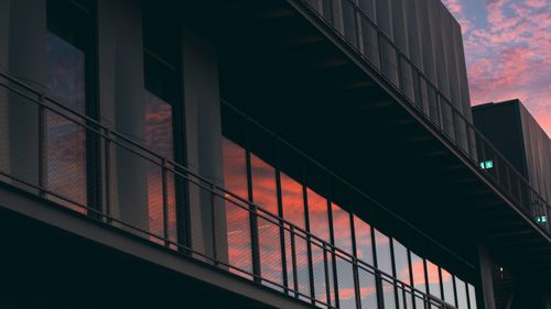 Free Contemporary building with glass reflections of a vivid sunset sky. Stock Photo